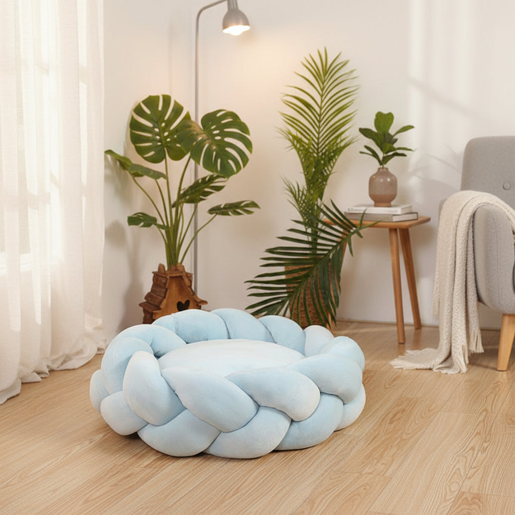 Panier rond tressé bleu clair pour chien et chat, dans un salon chaleureux avec parquet clair